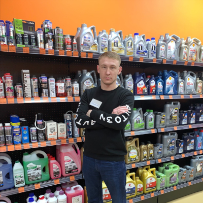 Владислав Мищенко, менеджер торговой сети AUTO3N в розничном магазине сети в Волгограде на фоне полок с моторным маслом.
