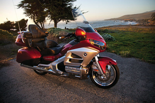 Красный туристический мотоцикл на видовой площадке с видом на море.